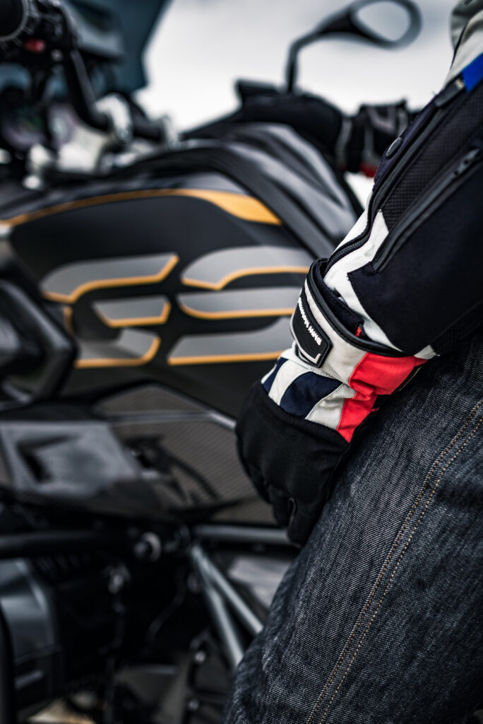 Motorradfahrer sitzt auf seiner BMW GS und trägt BMW Motorrad-Handschuhe