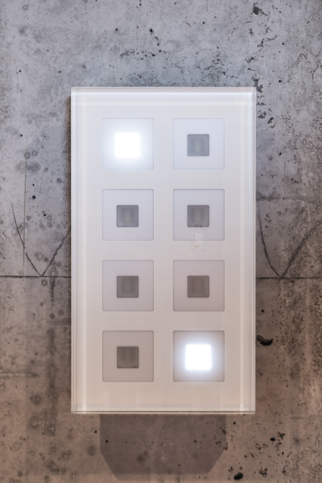 Beleuchteter Lichtschalter an einer Sichtbetonwand im modernen Haus